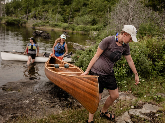 Paddlers lifting a canoe out of the water in the BWCA