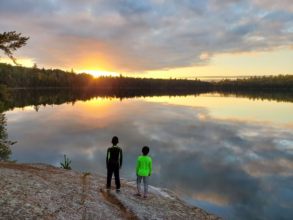 Two boys looking at sunset in the BWCA - Photo by Austin Fairchild