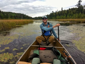 Smiling man paddling on a lake or river in the Boundary Waters