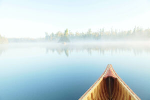 Canoe in water with fog on top of the water