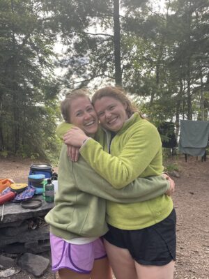 Two women hugging in a Boundary Waters campsite
