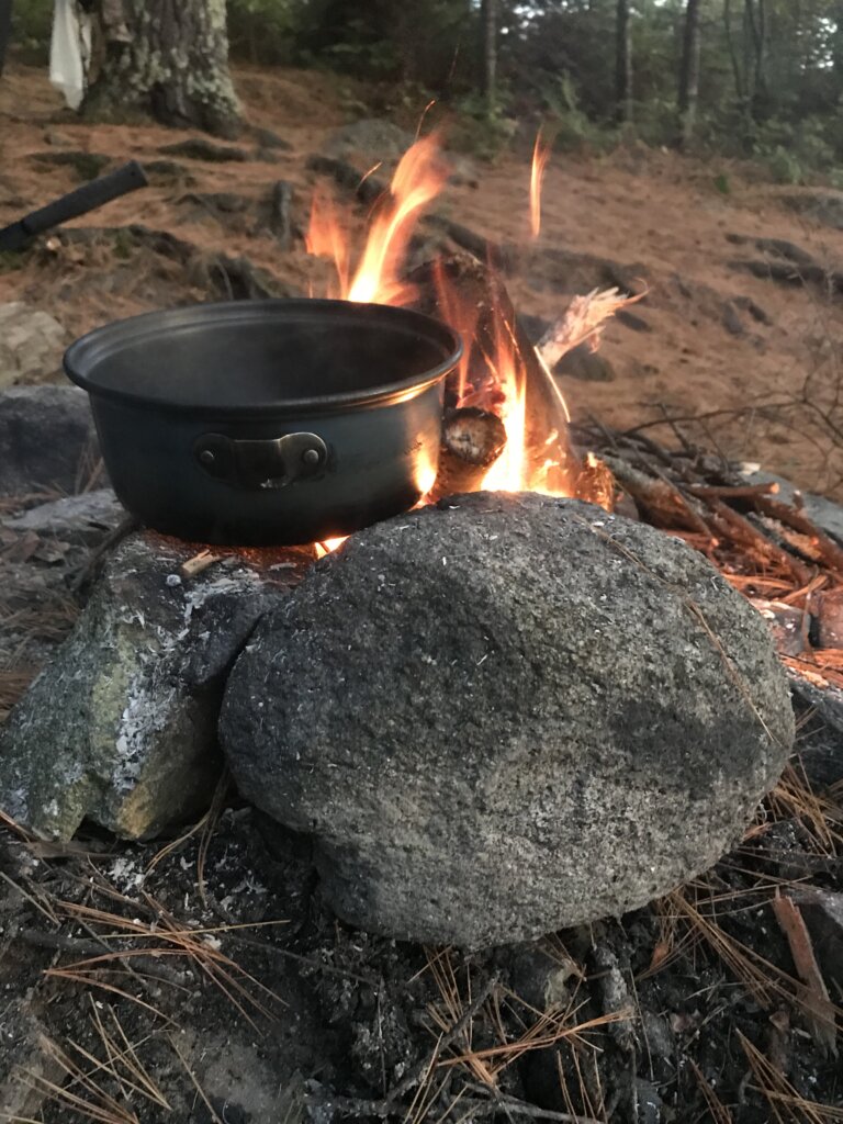 Cookpot with flames on a rock