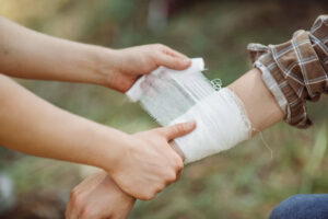 Image of an injury to the arm being treated with wraps and gauze.