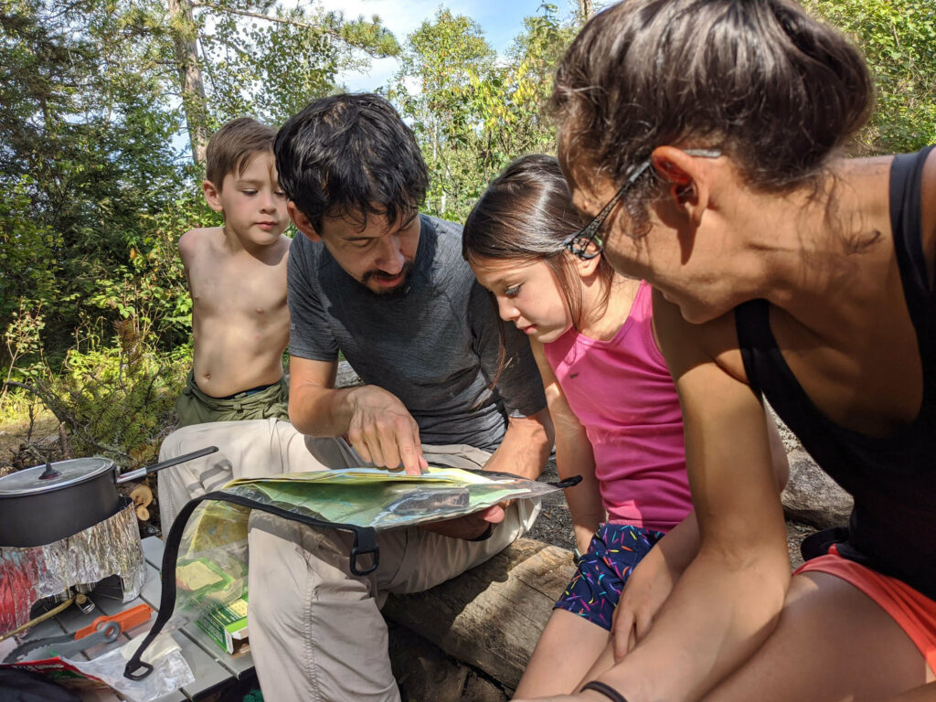 Image of a family navigating the Boundary Waters using a map. 