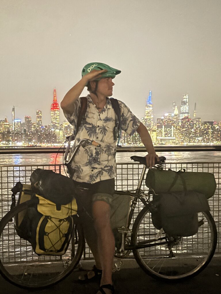 Mike Quirk astride his bike with the NYC skyline in the background.