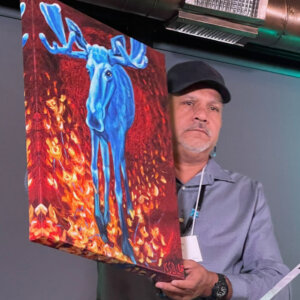 Kevin Dupuis, Chairman of the Fond du Lac Band of Lake Superior Chippewa holding a piece of art from Indigenous First Arts and Gifts.