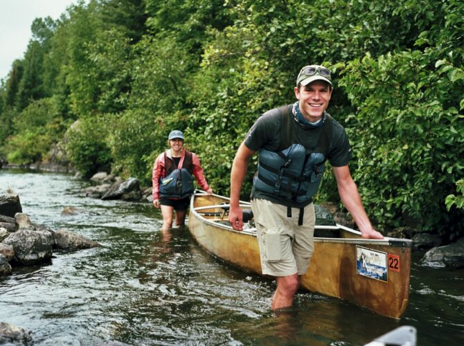 Paddlers guiding a canoe through a shallow river in the BWCA