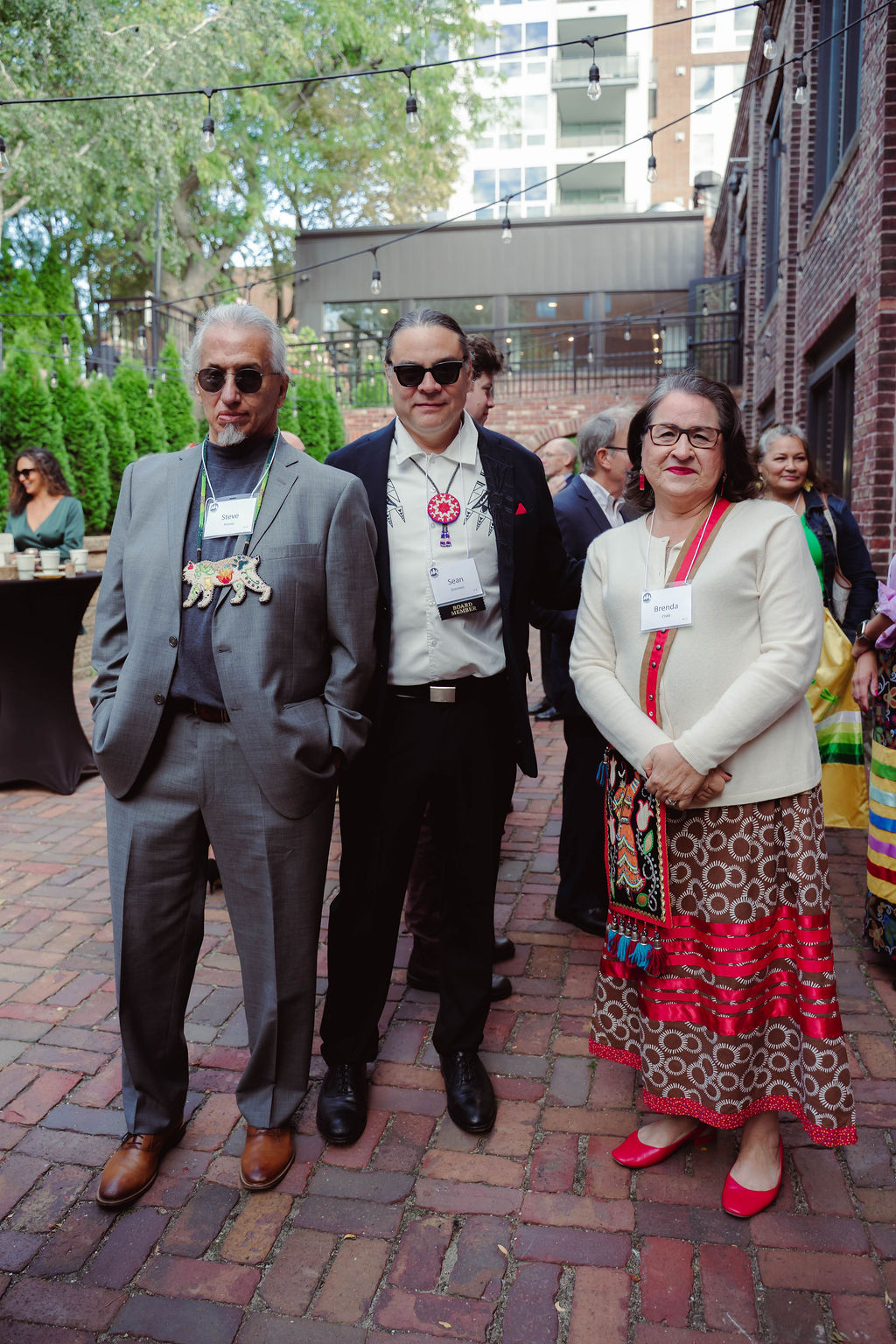 Three people dressed up and looking cool with sunglasses and Native pendants.