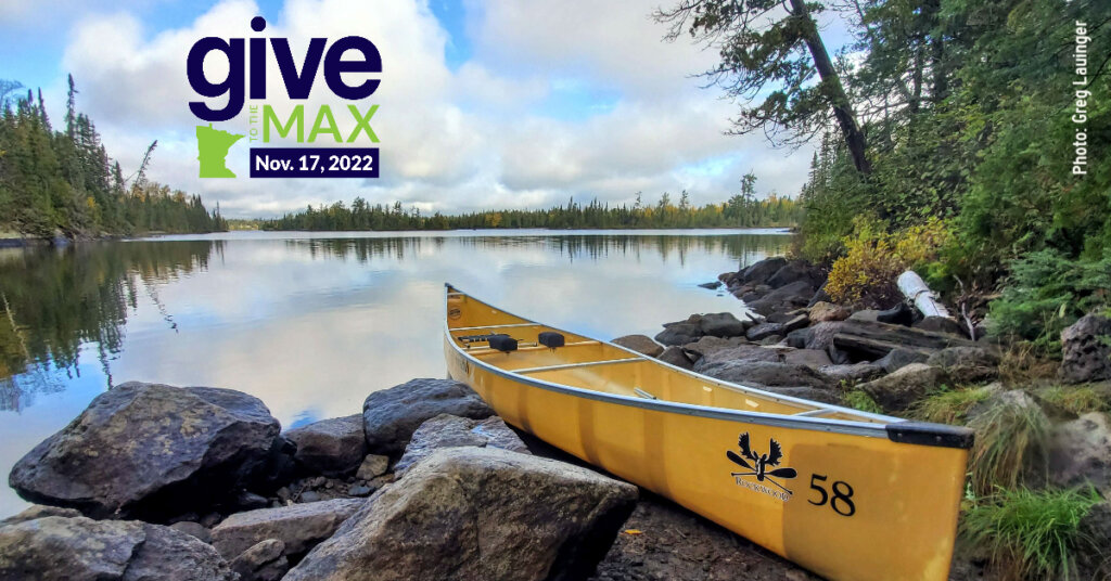 Canoe on Rocks in the Boundary Waters with Give to the Max Logo