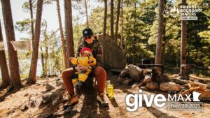 Woman holding baby on her lap in a Boundary Waters campsite