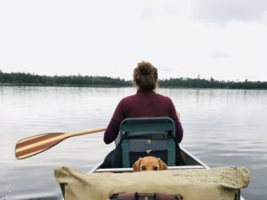 Image of a dog and woman canoeing the Boundary Waters.