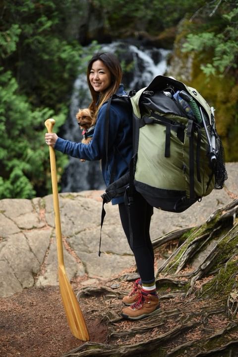 Friends of the Boundary Waters explaining how to pack for a trip to the Boundary. Image of a woman with her backpack on exploring the Boundary Waters