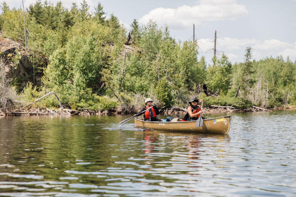 Kaohly Her steers to the next portage with Pa Der Vang in bow, in a canoe in the Boundary Waters.