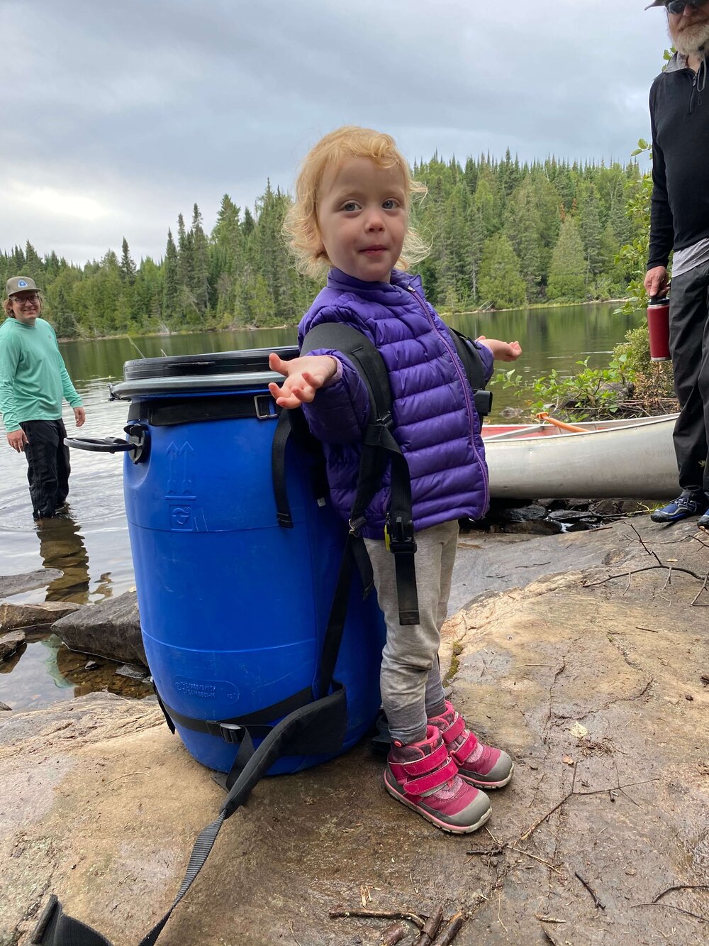 A kid lifting a blue bear barrel