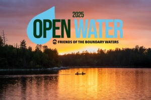Two canoeists paddle across a lake reflecting golden sunset - text 2025 Open Water