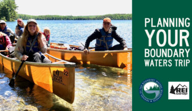 Family sitting in a canoe in the BWCA - Text says 