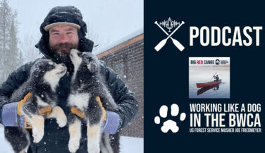 A man in the snow holding two dogs - Text reads