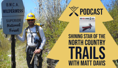 Bearded man in a hardhat standing next to a BWCA Sign. Text Reads 