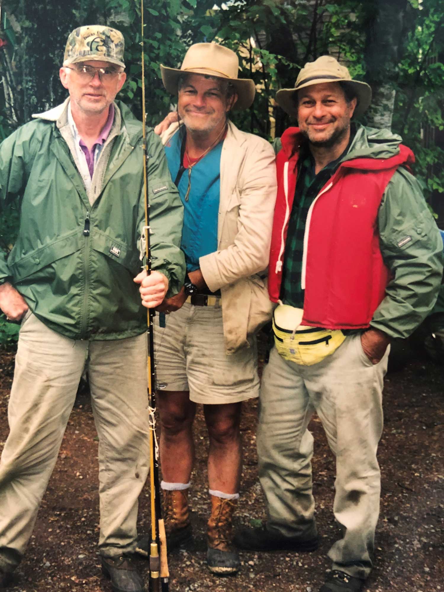 Three friends, decked out in fishing gear smile for the camera in the Boundary Waters.