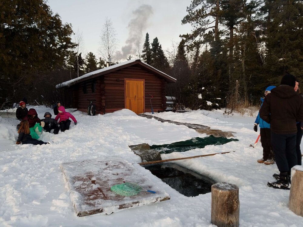 The sauna is cooking and there’s a hole in the ice at Camp Menogyn