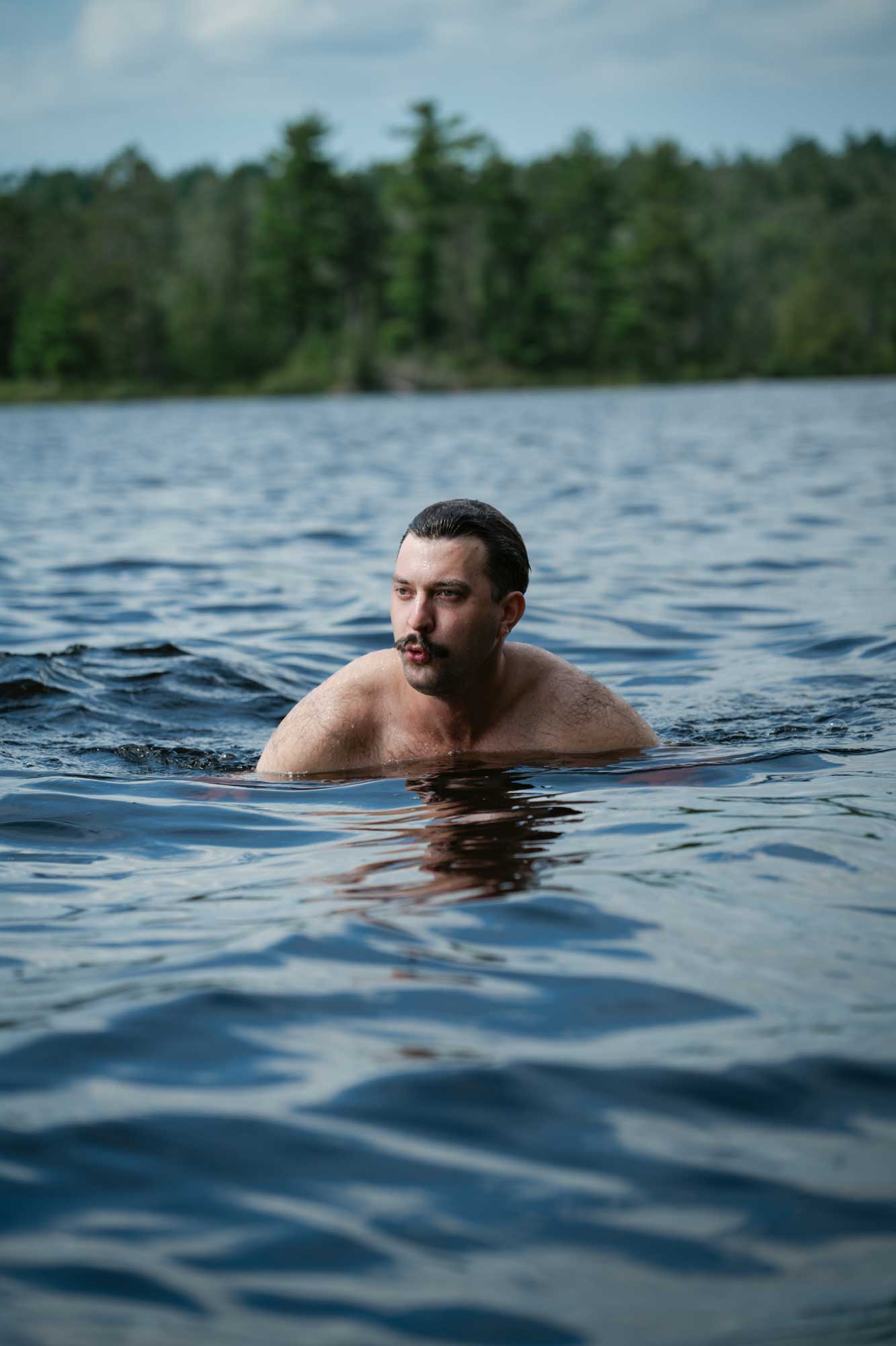 Man swimming and posing in a Boundary Waters Lake