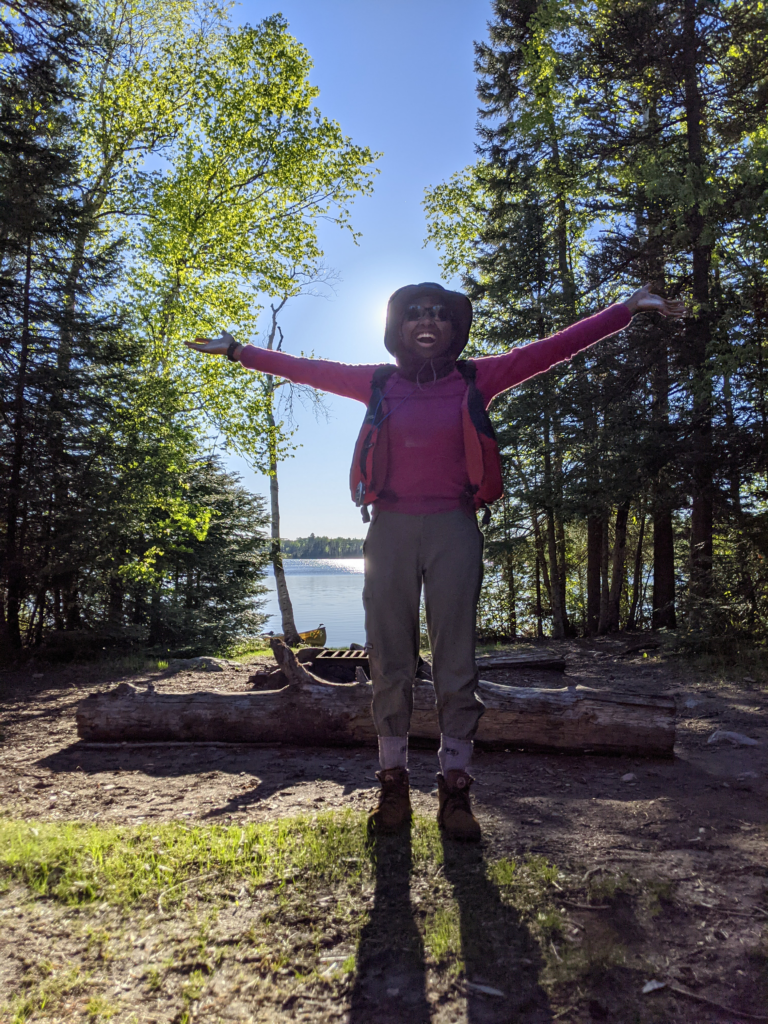 Bionca Davis looking joyful holding up her arms in the sunshine.