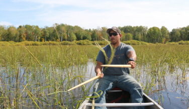 Darin Powell beats rice kernel into the hull of his canoe.