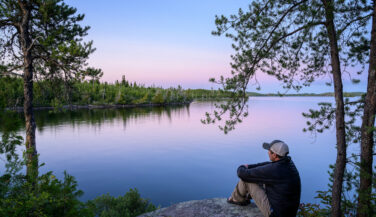 Man looking over a lake from a campsite in the Boundary Waters.