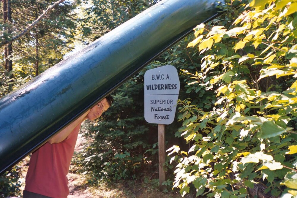 Man portaging a canoe in the BWCA Wilderness