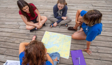 Tweens sitting around a map of the BWCA