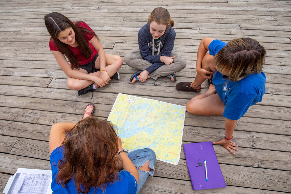 Tweens studying a map of the Boundary Waters